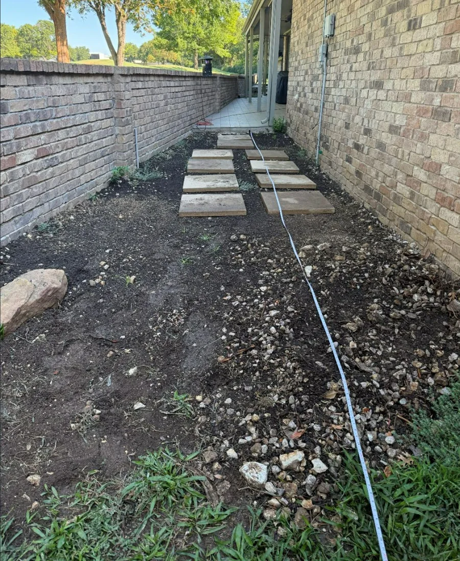 Narrow side yard with stepping stones and uneven ground evaluated for a central drainage route