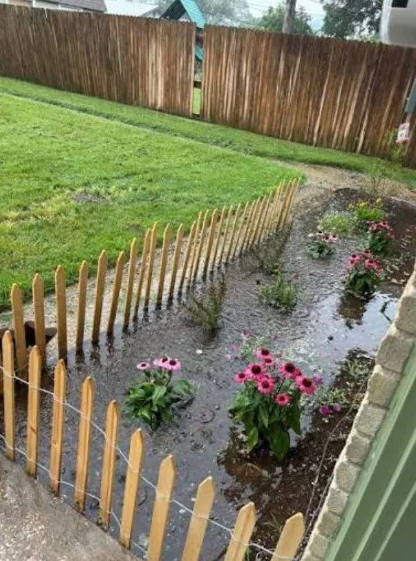 Runoff collecting along a wood fence and landscape bed